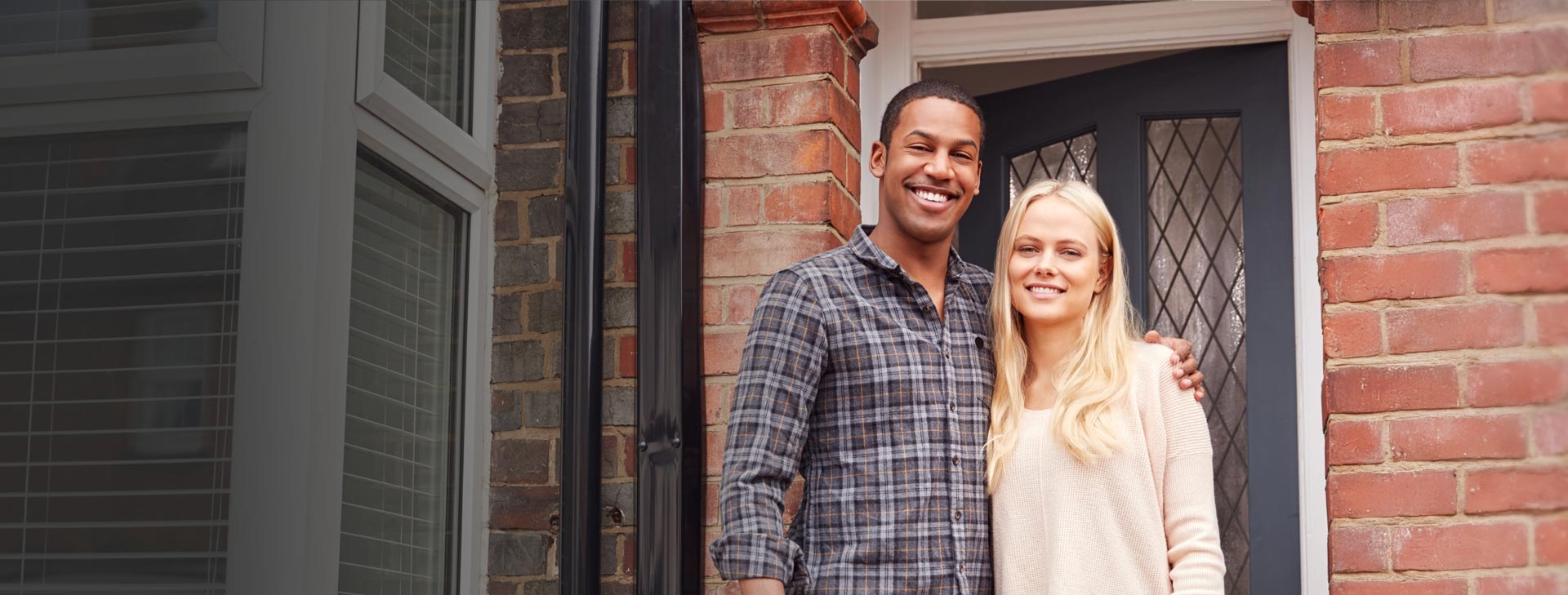 Couple standing outside home