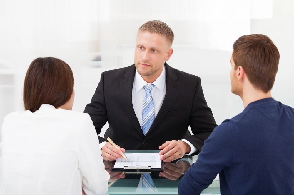Divorce mediator sits with man and woman